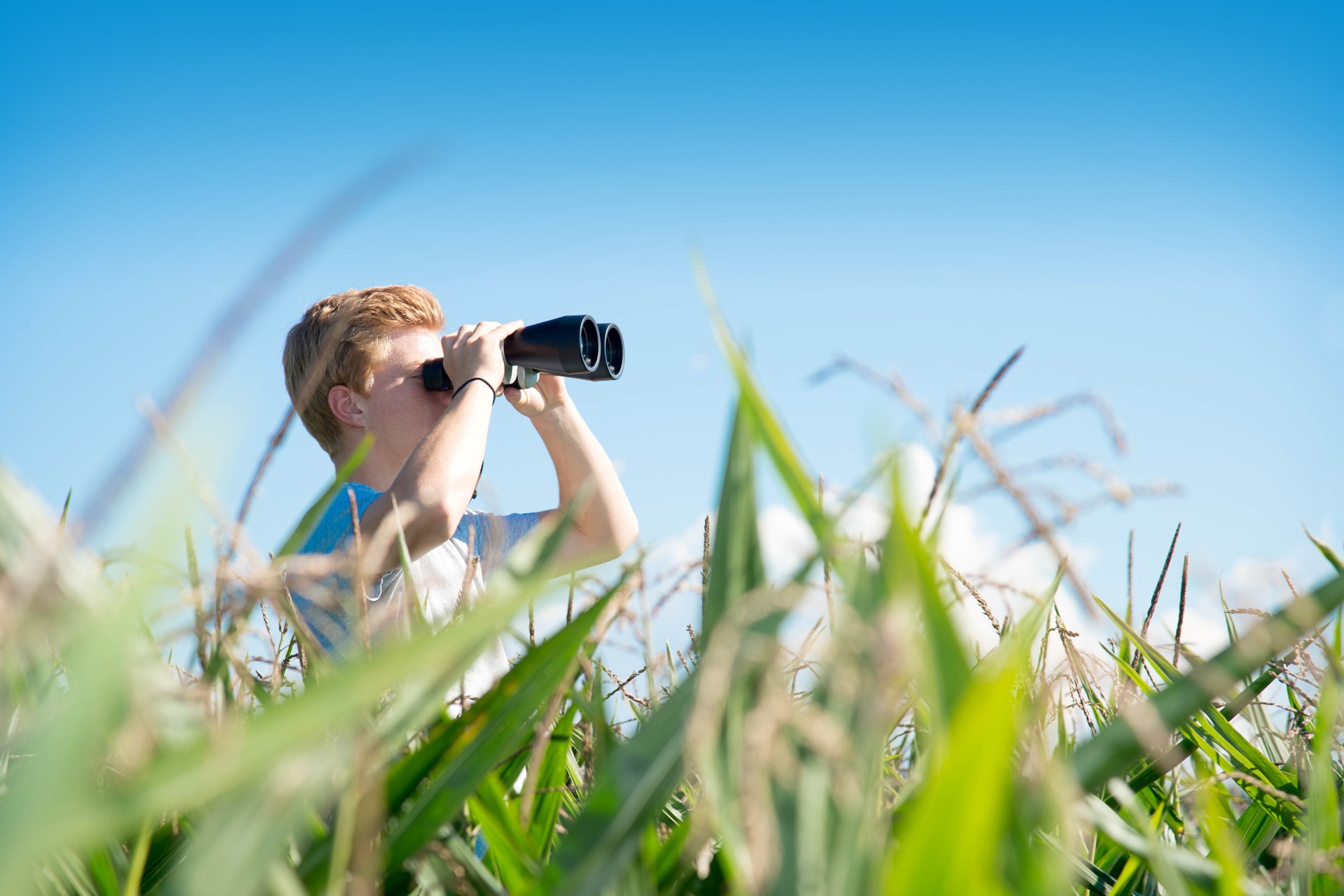 Mann schaut mit Fernglas in die Ferne